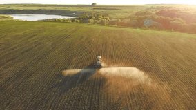 tractor with sprinkler machine is irrigating farmland in summer morning, aerial view above picturesque sown agricultural field in sunrise or sunset, modern irrigation system in farm fields - Powered by Shutterstock - Get 15% off with code: PIKWIZARD15