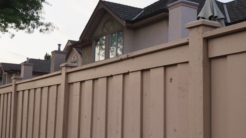 Suburban Privacy: Wooden Fence Along Residential Homes Royalty-Free Stock Footage #1111096413