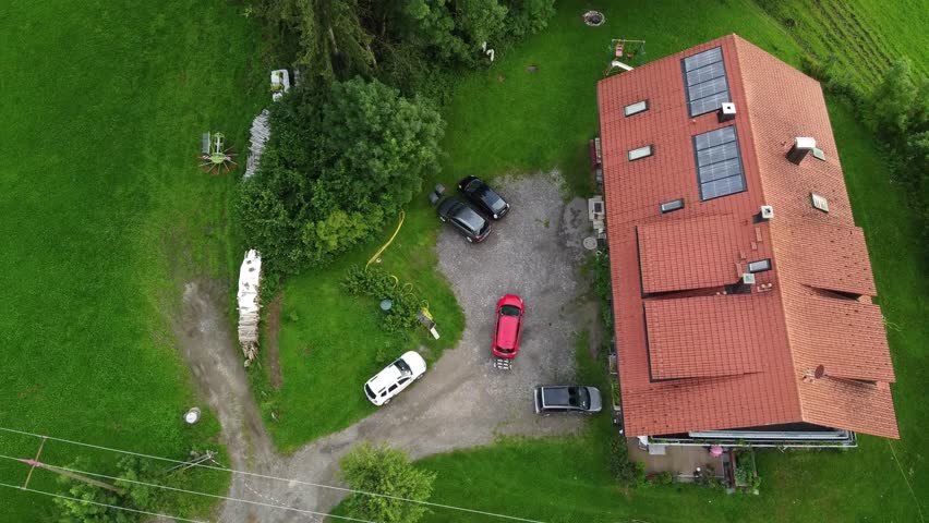 4k drone shot of a red car driving in a hilly Landscape.