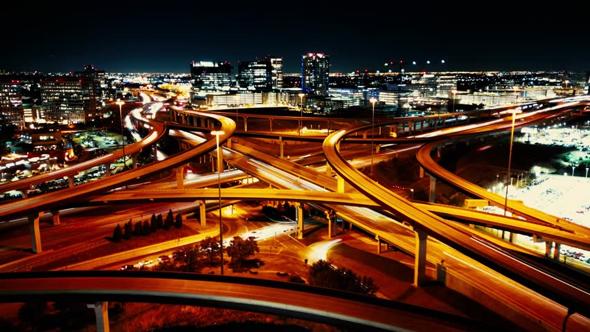 A drone timelapse of bridges and illuminated buildings of a city at night
