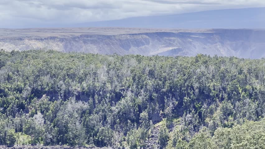 Cinematic long lens panning shot of the Kilauea Crater from an overlook on the Kilauea Iki trail in Hawai