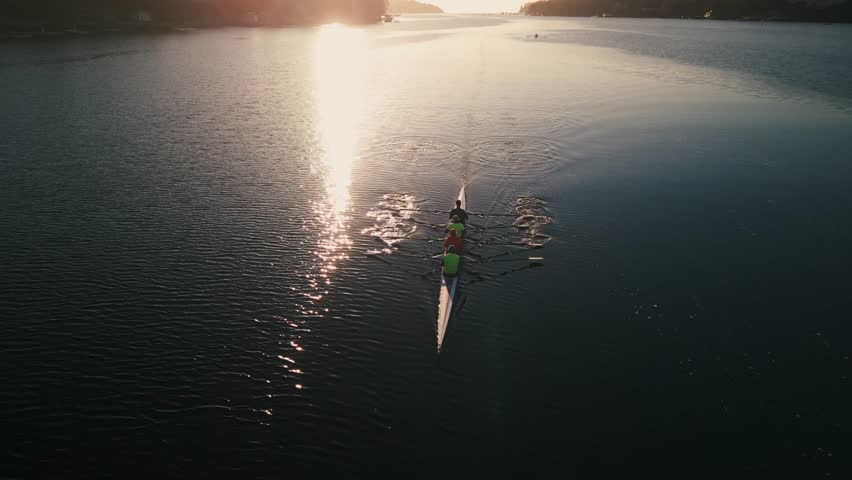 Sports Rowing Boat with a Crew of Young Sportsmen. Drone Shot of a Sport Canoe Being Driven by a Team of Young Women and Men in an Ocean Bay with a Beautiful Sunrise, Nova Scotia, Halifax. Canada.