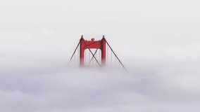 Inspirational drone flight around red tower above epic ocean of clouds covering San Francisco Bay until horizon. Breathtaking background California USA 4K. Aerial video of the Golden Gate Bridge