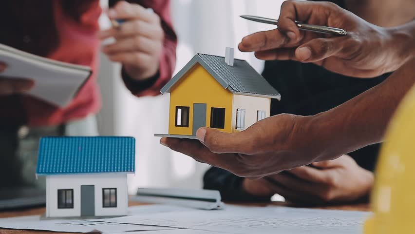 Architects, engineers and homeowners meeting at construction site.