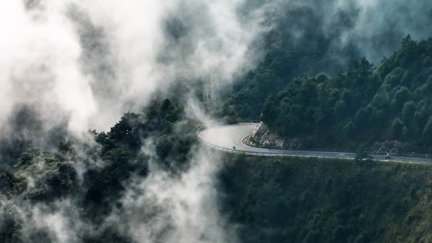 Aerial view of motorcycle rider and curvy road on the  mountains