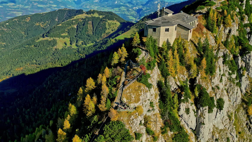 Left to right pan shot capturing the place eagles nest in Germany a building situated at the top of the hill with great view of the valley in the distance behind the building 