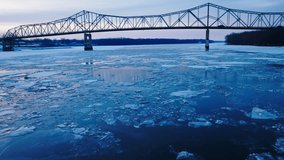 Drone video flying over chunks of ice with bridge in view