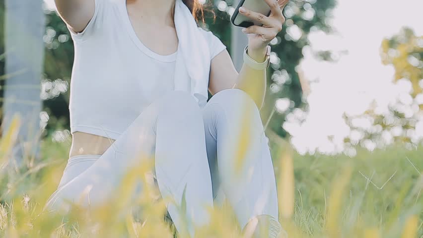 Young woman stretching before running while looking for beautiful landscape on roadside. Sports and Recreation.