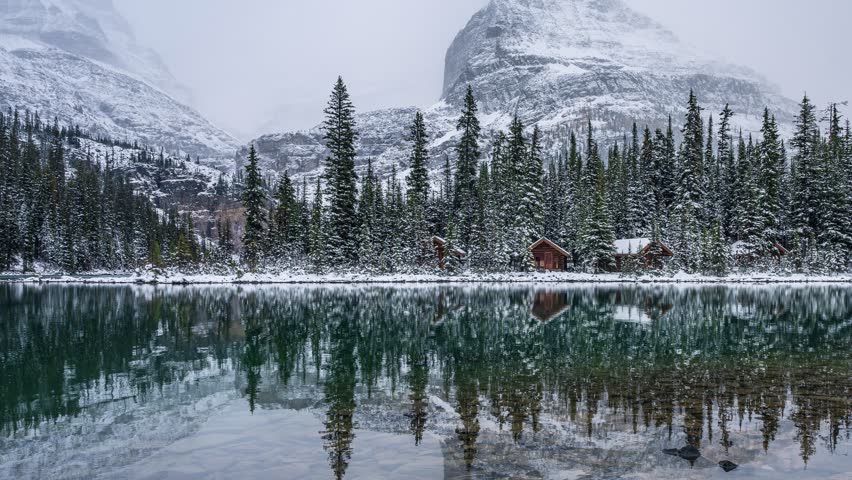 Time lapse beautiful scenery of Lake Ohara with wooden cottage in snowy pine forest and lake reflection on winter at Yoho national park, British Columbia, Canada