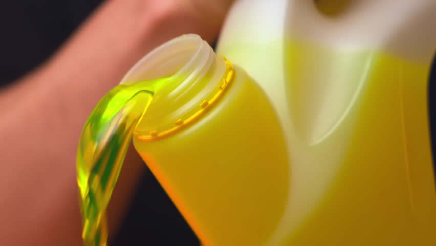 Male assistant pours yellow paint from container preparing for movie decoration. Assistant pours paint creating bright background for movie scene