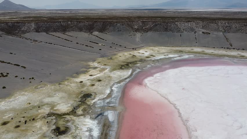 Chipaya Meteor impact crater farming inside the crater Bolivia with white and pink water in the crater Aerial video