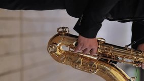 Saxophonist musician playing saxophone or sax at the concert or party. Saxophonist live performance. Saxophonist play on golden saxophone, close up. Jazz music. vertical orientation video