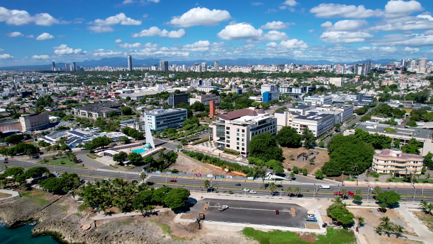 Aerial cinematic footage of the city of Santo Domingo, Capital Of Dominican Republic, its beautiful streets and buildings, la Fuente Centro de los Heroes, the Pabellón de las Naciones