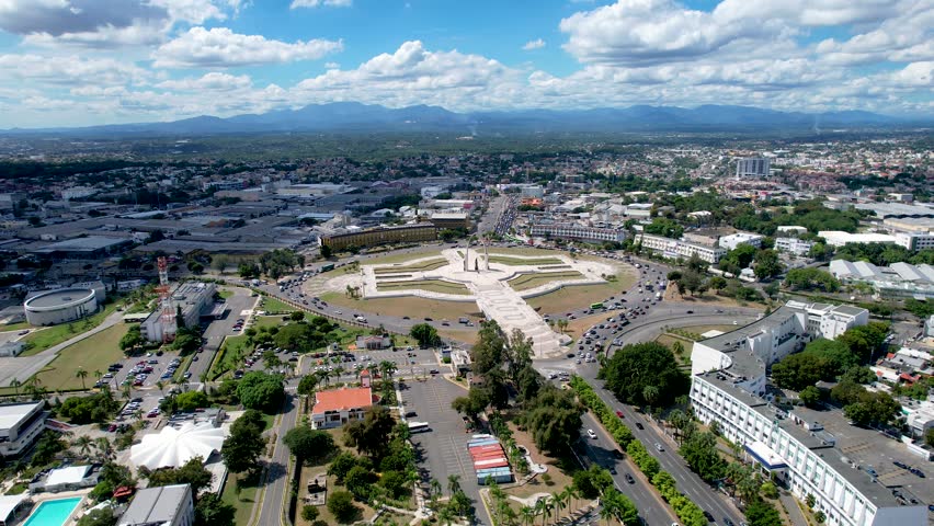 Aerial cinematic footage of the city of Santo Domingo, Capital Of Dominican Republic, its beautiful streets and buildings, la Fuente Centro de los Heroes, the Pabellón de las Naciones