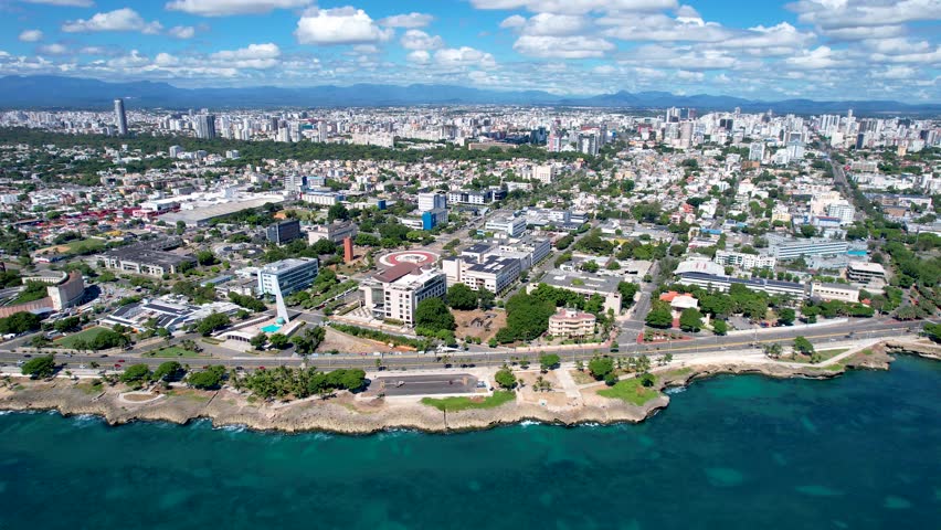 Aerial cinematic footage of the city of Santo Domingo, Capital Of Dominican Republic, its beautiful streets and buildings, la Fuente Centro de los Heroes, the Pabellón de las Naciones