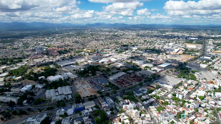 Aerial cinematic footage of the city of Santo Domingo, Capital Of Dominican Republic, its beautiful streets and buildings, la Fuente Centro de los Heroes, the Pabellón de las Naciones