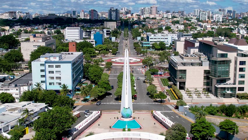 Aerial cinematic footage of the city of Santo Domingo, Capital Of Dominican Republic, its beautiful streets and buildings, la Fuente Centro de los Heroes, the Pabellón de las Naciones