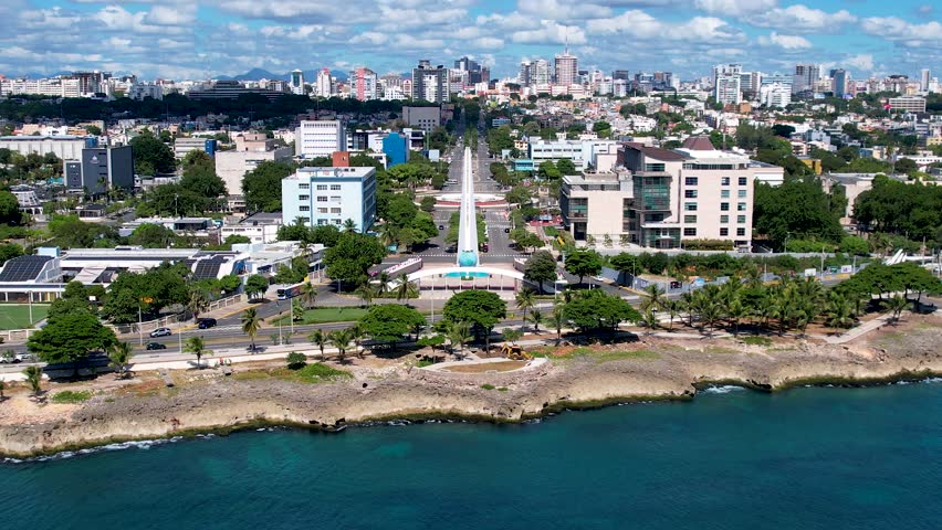 Aerial cinematic footage of the city of Santo Domingo, Capital Of Dominican Republic, its beautiful streets and buildings, la Fuente Centro de los Heroes, the Pabellón de las Naciones