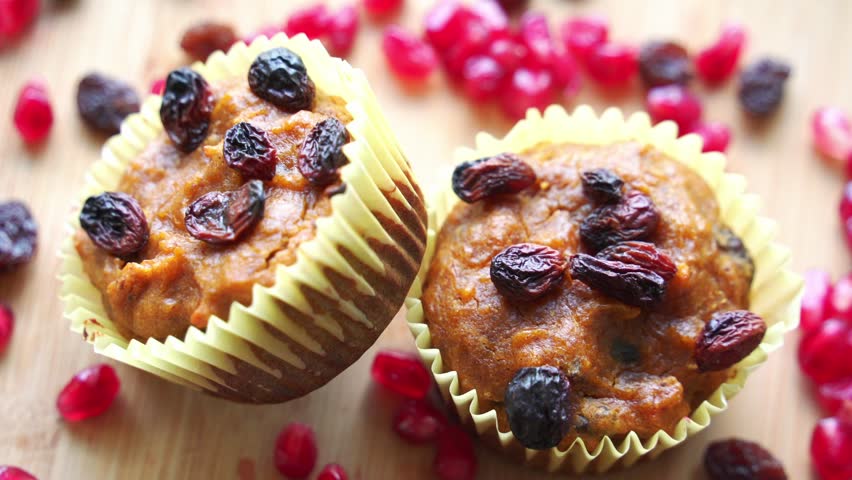 Beautiful vibrant shot of raisins cranberries on vegan pumpkin muffins using real roasted pumpkin in bowl healthy dairy-free recipe vegan