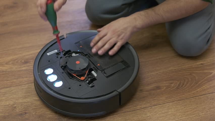 Repairman changing batteries on robotic vacuum cleaner. robot vacuum cleaner repair. High quality photo