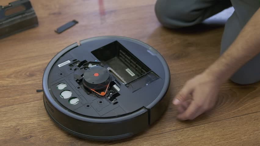 Repairman changing batteries on robotic vacuum cleaner. robot vacuum cleaner repair. High quality photo