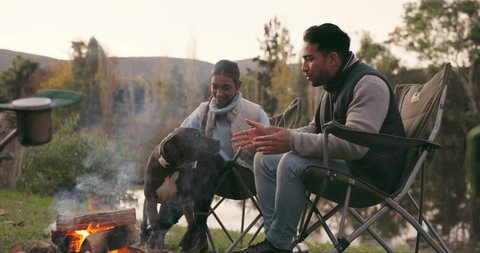 People, camping with a dog and fire in nature, outdoor adventure or friends together on holiday, trip or relax in the woods. Couple, campfire and man with a pet bonding, quality time or fun vacation 스톡 비디오