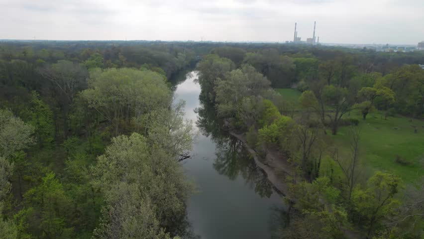 Aerial drone forward moving shot over river with trees on both sides in Prater Park, Vienna, Austria on a cloudy day. Royalty-Free Stock Footage #1111186641