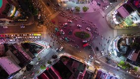 Vertical video. Aerial time-lapse of evening traffic at an intersection in Ho Chi Minh City, Vietnam.