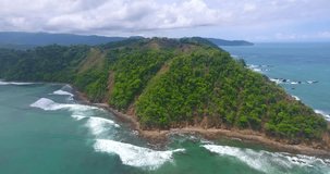 Drone shot overlooking the lush green hills of Playa Herradura in Costa Rica on a cloudy day in paradise