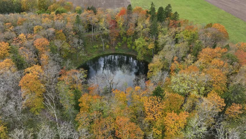 Approaching aerial view of Kaali meteorite crater in Saaremaa, Estonia.