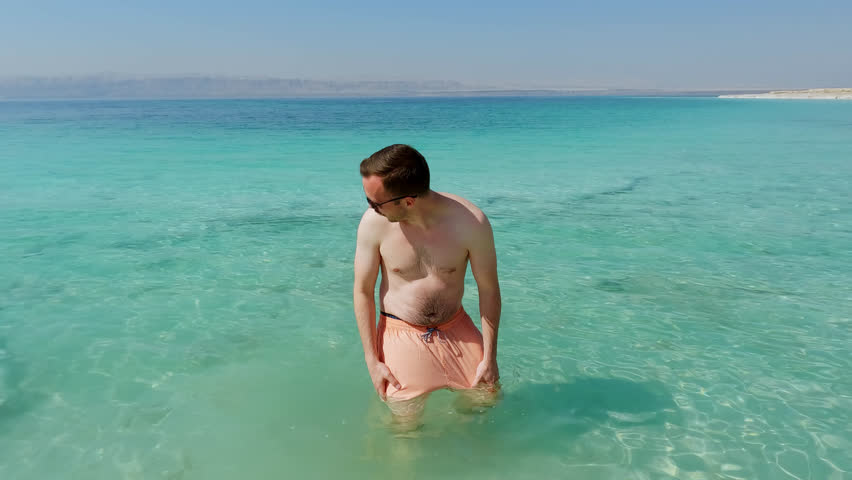 Happy Tourist Lays Down in Dead Sea and Floats Easily. Famous Salty Lake. Israel