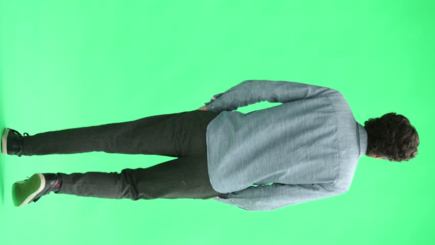 young man in full growth. isolated on green background. view from the back