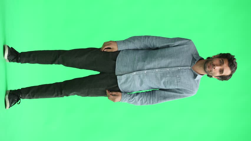 full-length portrait of a young man. standing isolated on green background