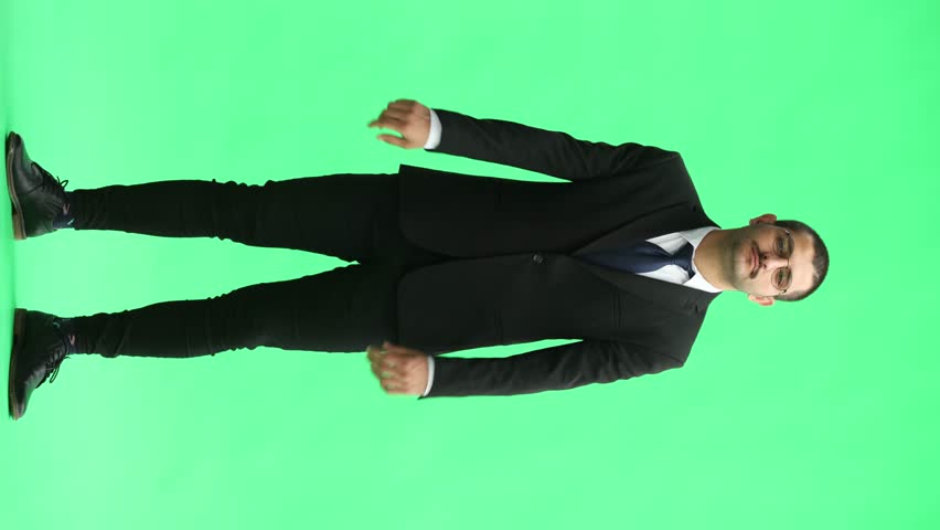 full-length portrait of a young man. standing isolated on green background