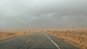 time lapse clip of driving trough monument valley while storm covers street with sand