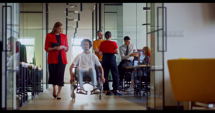 African American businessman in a wheelchair engages in a professional discussion with his colleague, addressing various business challenges and exploring solutions in an inclusive and diverse modern Royalty-Free Stock Footage #1111216699
