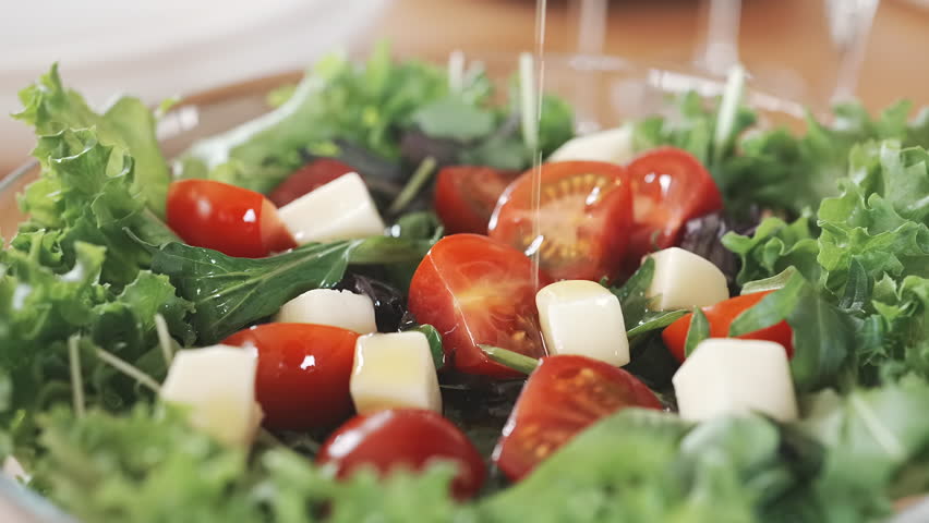 Drizzling Olive Oil on Italian Salad