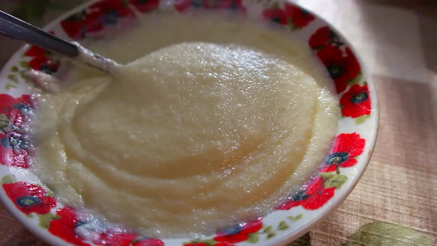 spoon in a plate with semolina porridge. Putting butter into bowl with semolina milk porridge, Hot steaming healthy traditional breakfast. High angle.Healthy breakfast. white boiled porridge Royalty-Free Stock Footage #1111231709