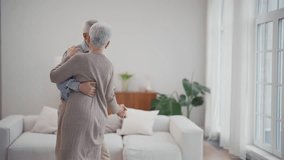 Happy smiling couple of senior wife and husband dancing together in living room at home. Gray haired man and woman. Family romantic relationship in old age concept. Elderly active people dance. - Powered by Shutterstock - Get 15% off with code: PIKWIZARD15