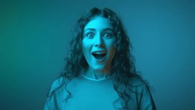 Surprised Portrait of Young Woman with Shocked Face Expression Looking at Camera Isolated on Neon Background. Happy Girl Watching Emotional Presenting with Open Mouth. Front Shot of Smiling Individual - Powered by Shutterstock - Get 15% off with code: PIKWIZARD15