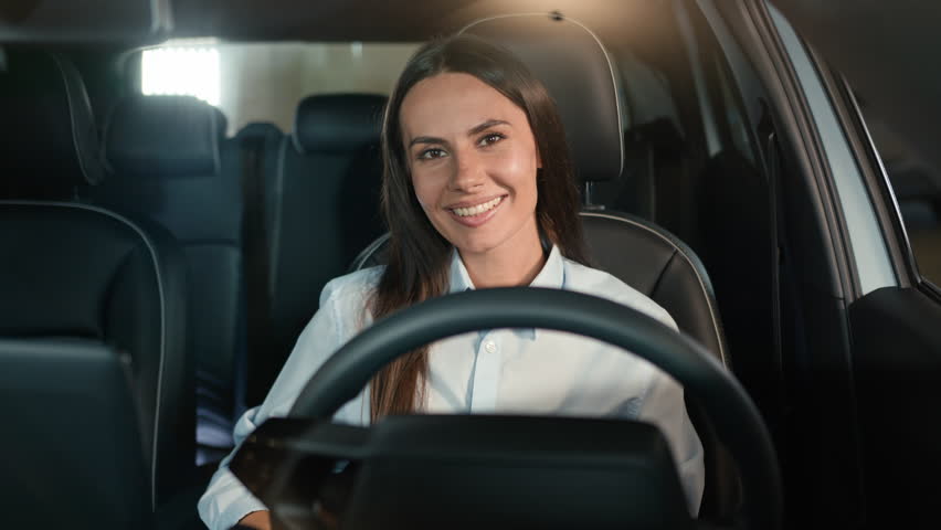 Happy joyful toothy smiling Caucasian woman smile looking at camera sit inside new rental luxury modern car girl female driver in automobile driving auto transport businesswoman lady at parking lot