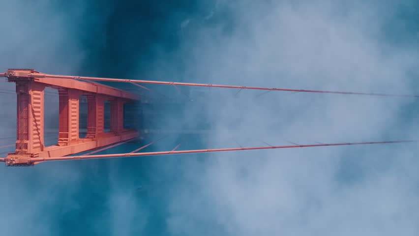 Aerial of red Golden Gate bridge. Busy road of red bridge over deep blue Pacific Ocean waters. Top down fog drifting around industrial architecture construction in San Francisco bay, California USA 4K Royalty-Free Stock Footage #1111236027