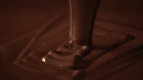 Slow motion shot pouring melted chocolate, close-up seamless dripping hot liquid chocolate flows, waves flowing molten chocolate or dark caramel sauce. Chocolate wavy drip. Confectionery cooking - Powered by Shutterstock - Get 15% off with code: PIKWIZARD15