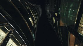 Low angle dolly shot illuminated skyscrapers cityscape at night, financial district looking up modern architecture office buildings, city business center downtown, gimbal shot, Warsaw evening street - Powered by Shutterstock - Get 15% off with code: PIKWIZARD15