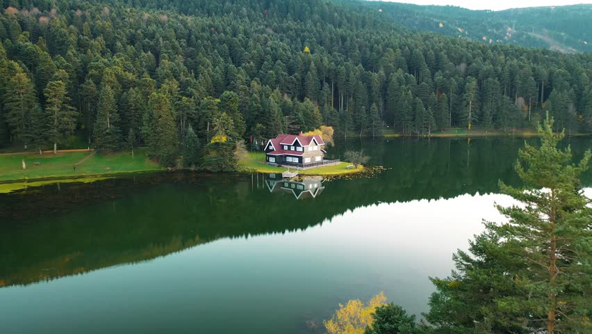 Wooden lake house on the water in the forest. View of Abant-Golcuk Lake. The harmony of blue and green. Magnificent lake view. Golcuk National Park Bolu, Turkey.