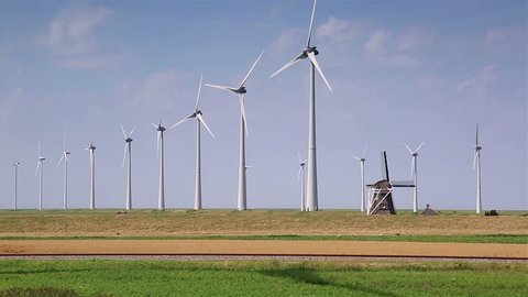 Modern wind turbines generating clean and renewable energy and the traditional, Dutch windmill Goliath.