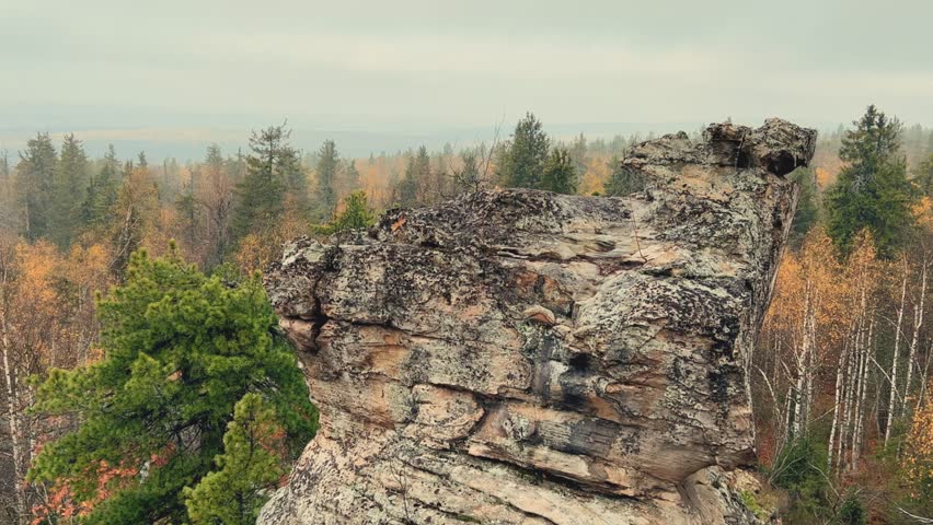 Stone City in autumn. Bright foliage and autumn landscape. The natural landscape is a rock formation in Central Russia, the Urals. A natural monument. Ancient rocky folding in the Ural Mountains. 4K