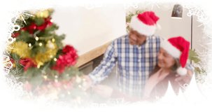 Animation of merry christmas text over diverse senior couple celebrating christmas at home. Chirstmas, celebration and tradition concept digitally generated video.