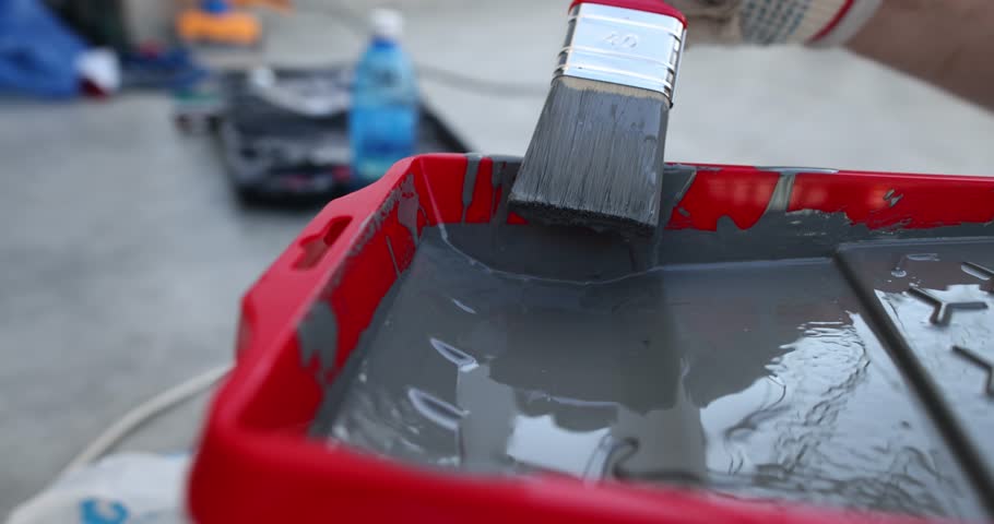Tray and paint container for home painting equipment. Story tray with gray paint and brush
