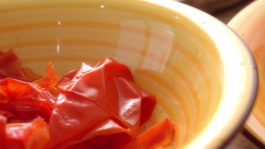 Dolly shot of Tomato Skins in Bowl and Peeled Tomato on Plate. Shallow DOF.